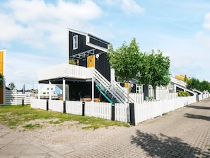 Moderni rakennus, jossa on tasakatto, portaikko ja valkoinen aita.