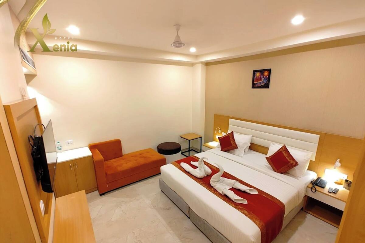 Habitación de hotel con cama, escritorio, silla y una mesita.