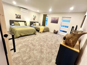 A bedroom with two beds, a large window, and a sculpture on a table. - Stylish 4BR Retreat in Denton | Sleeps 10 UNT TWU (Denton)