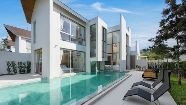 A modern two-story house with a swimming pool, outdoor seating, and a well-maintained garden. - LuxPride Villas Private Pool Tropiclook (Si Sunthon)