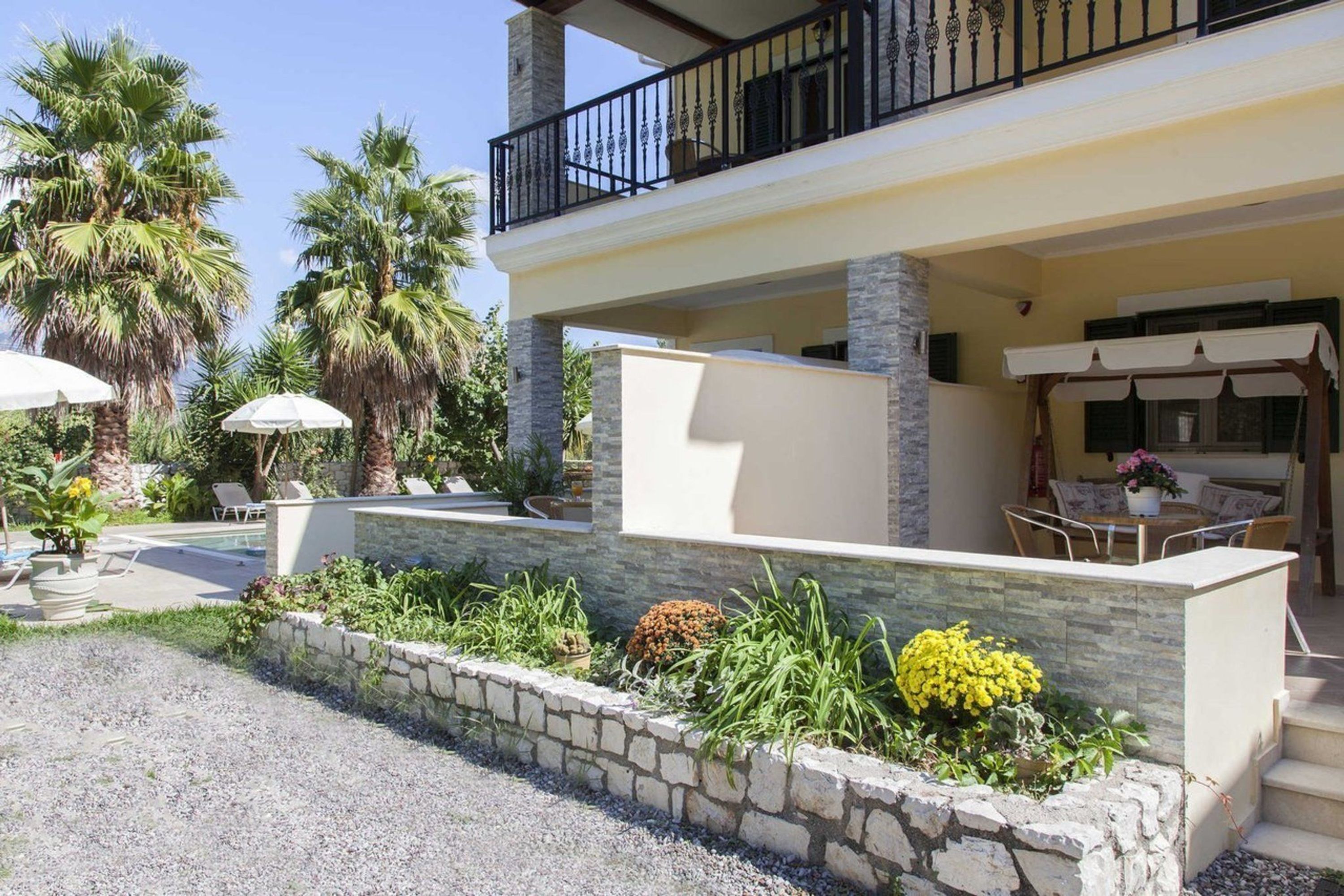 A two-story building with a balcony, outdoor seating area, and a pool.