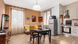 Una cocina compacta con una mesa de comedor, sillas, un refrigerador, un microondas y una estufa.