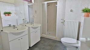 A modern bathroom with two sinks, a toilet, and a shower enclosure. - Fantastic Holiday Home by the sea (Sint Maartensvlotbrug)