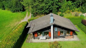 A single-story house with a sloped roof, a chimney, and a small porch.