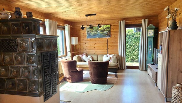 A cozy room with a fireplace, a sofa, and a large window with curtains.