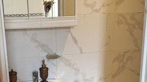 Ein Badezimmer mit weißem Waschbecken, Waschtisch und Toilette.