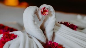 A towel with a heart shape and a flower. - Kurnia Guest House and Spa (Penida Island)