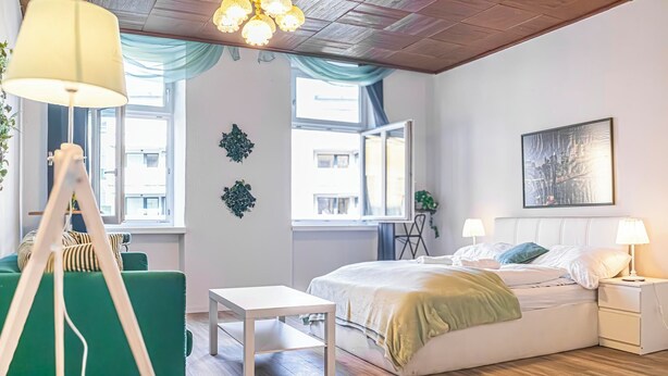 Un dormitorio moderno con cama, mesitas de noche, escritorio y una silla.
