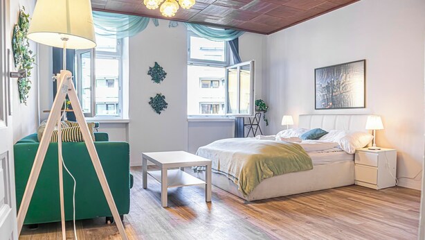 Ein Schlafzimmer mit Bett, Nachttischen, Schreibtisch und Fenster.
