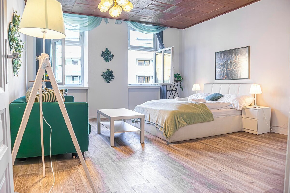 Ein Schlafzimmer mit Bett, Nachttischen, Schreibtisch und Fenster.