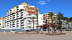 Un hôtel à plusieurs étages doté de balcons, situé en bord de mer, et portant l’enseigne « Hôtel Servidor ».