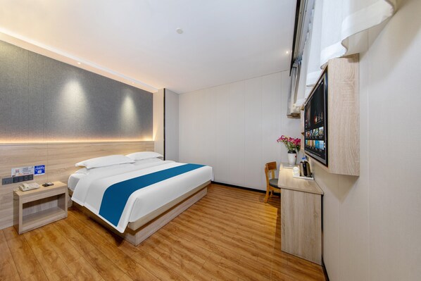 A modern hotel room with a large bed, a bedside table with a phone, a desk with a computer monitor, and a wall-mounted TV. - Winsome Hotel Guangzhou Tianhe Keyun Road Branch (Guangzhou)