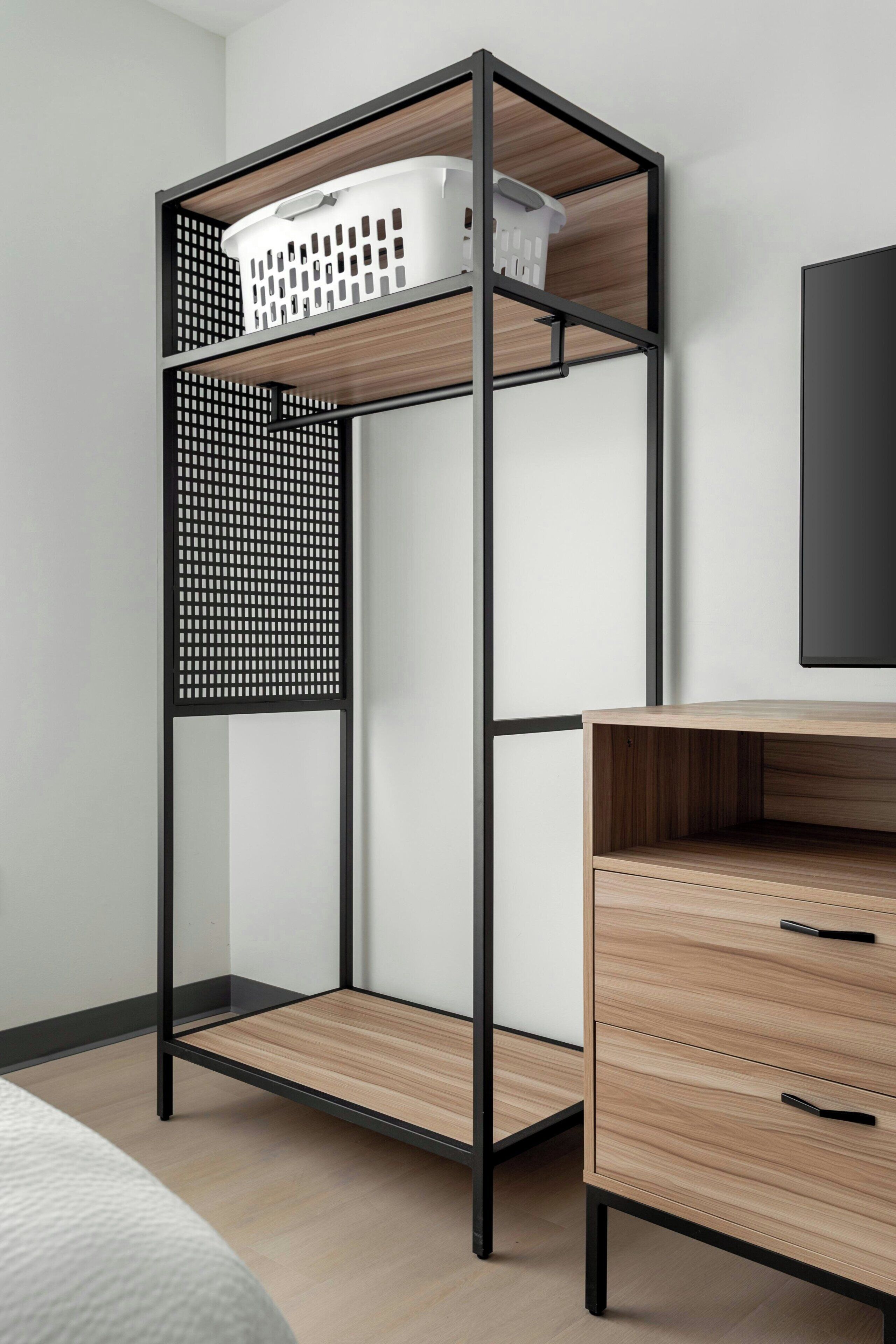 A bunk bed with a wooden frame and a white laundry basket on top.