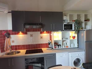 A compact kitchen with a built-in oven, microwave, and dishwasher.