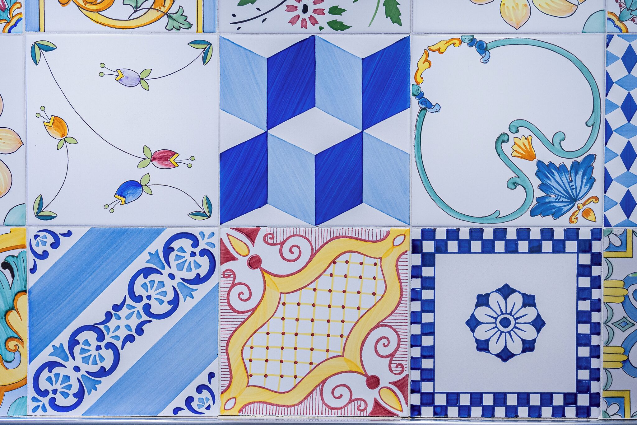 Verschillende kleurrijke tegelpatronen, waaronder geometrische vormen en bloemmotieven.