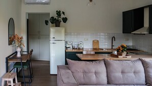Eine moderne Küche mit Kühlschrank, ein Essbereich mit Tisch und Stühlen sowie ein Wohnzimmer mit Sofa.