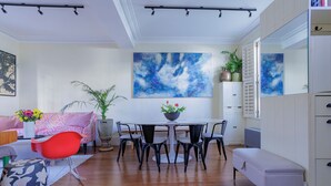 Un salon moderne comprenant une table à manger, des chaises, un canapé et un banc.