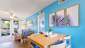 A bright room with a wooden dining table, blue walls, and framed leaf artwork. - Designer Resort Style - 1 King Bed Apartment, Pool, Gym in beautiful Gilbert AZ (Gilbert)