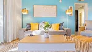 A living room with a sofa, two armchairs, a coffee table, and a potted plant. - Designer Resort Style - 1 King Bed Apartment, Pool, Gym in beautiful Gilbert AZ (Gilbert)