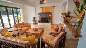 A spacious living area with a sofa set, a coffee table, and a TV. - LA BELLE RESIDENCE (Mahe Island)