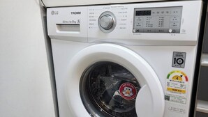 A front-loading LG TROMM washing machine with a digital display, water level indicator, and a 10 kg capacity label. - Seaview & City Lights Retreat, Marine City (Busan)