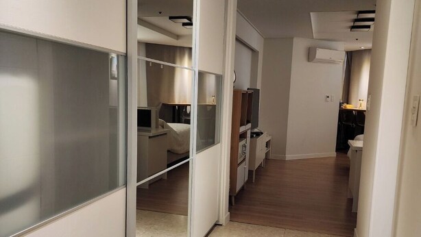 A hotel corridor with a sliding door leading to a bedroom, a kitchenette, and a bathroom. - Seaview & City Lights Retreat, Marine City (Busan)