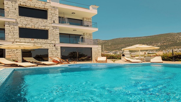 Ein modernes Gebäude mit Pool, Liegestühlen und Sonnenschirmen.