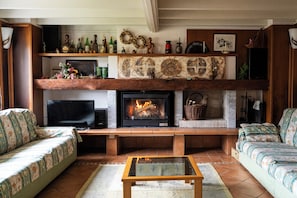A living room with a fireplace, television, sofa, and coffee table.