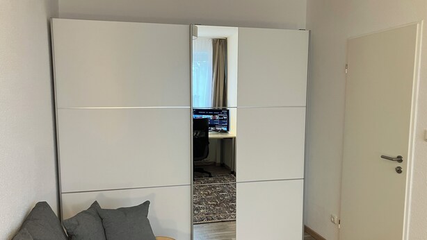 A bedroom with a bed, a wardrobe, and a door. - At Biebrich Palace Park (Wiesbaden)