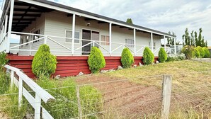 A two-story house with a porch, a red front step, and a fenced yard. - Quiet Farm-style Retreat With Scenic Views (Durham Lead)
