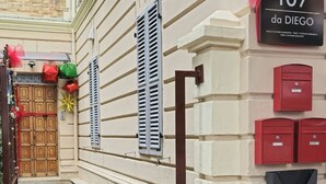 A building with a sign reading "107 da DIEGO" and a wooden door with festive decorations. - 60sqm downtown with garden | Casa Da Diego (Civitanova Marche)