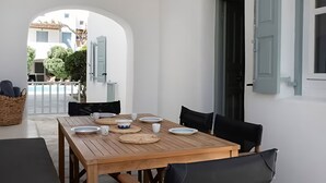 Ein Esszimmer mit Holztisch, Teller, Schüsseln und Tassen, umgeben von Stühlen.