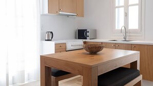 Eine moderne Küche mit Holzausbau, einer weißen Arbeitsplatte, einem Herd, einer Mikrowelle und einem Spülbecken.