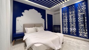 A modern bedroom with a bed, a nightstand, and a decorative wall panel.