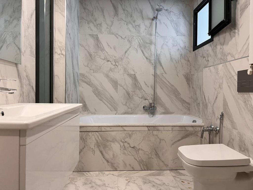A bathroom with a bathtub, a toilet, and a shower.