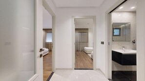 A modern hotel hallway with a bed, a bathroom, and a vanity. - Seven Floors (Tunis)