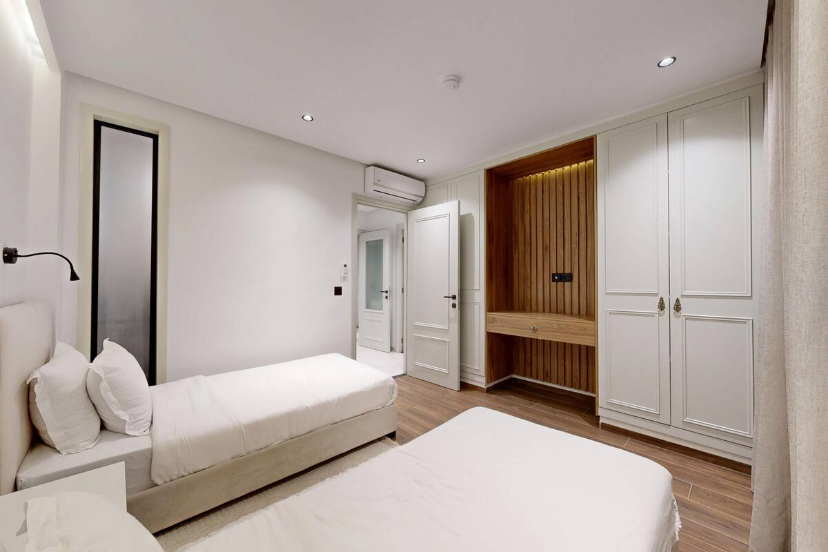 Un dormitorio con cama, mesita de noche, armario y espejo.