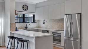 Una cucina moderna con isola centrale, elettrodomestici in acciaio inossidabile e un'ampia finestra.