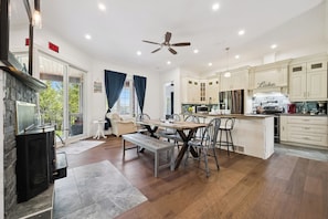 A spacious kitchen with a central island, wooden flooring, and a built-in stove.