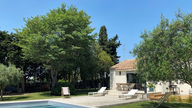 A swimming pool with lounge chairs and a small building with a tiled roof. - House with swimming pool and large garden near the sea (Montbazin)