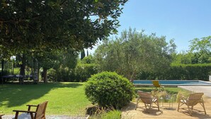A wooden deck with outdoor furniture, a swimming pool, and a well-maintained lawn. - House with swimming pool and large garden near the sea (Montbazin)