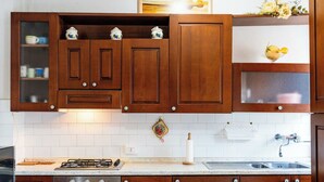 A kitchen with wooden cabinets, a gas stove, an oven, and a sink. - Lovely apartment for 6 people with WIFI and balcony (Riva Ligure)
