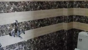 A bathroom with a marble floor, a sink, and a toilet. - Shree Siddhivinayak Hotel  (Achrol)