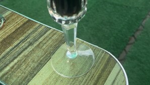 A glass of dark beer on a table with a green surface. - Paskandy Hotel (Amasaman)