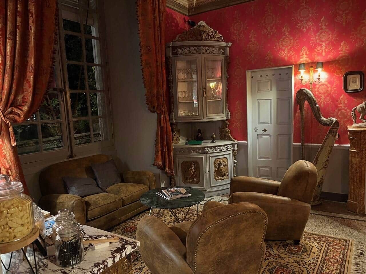Un salon traditionnel avec un canapé, des fauteuils, un buffet et une table.