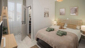 Una camera da letto con un letto, un comodino, una lampada e un'opera d'arte appesa al muro.