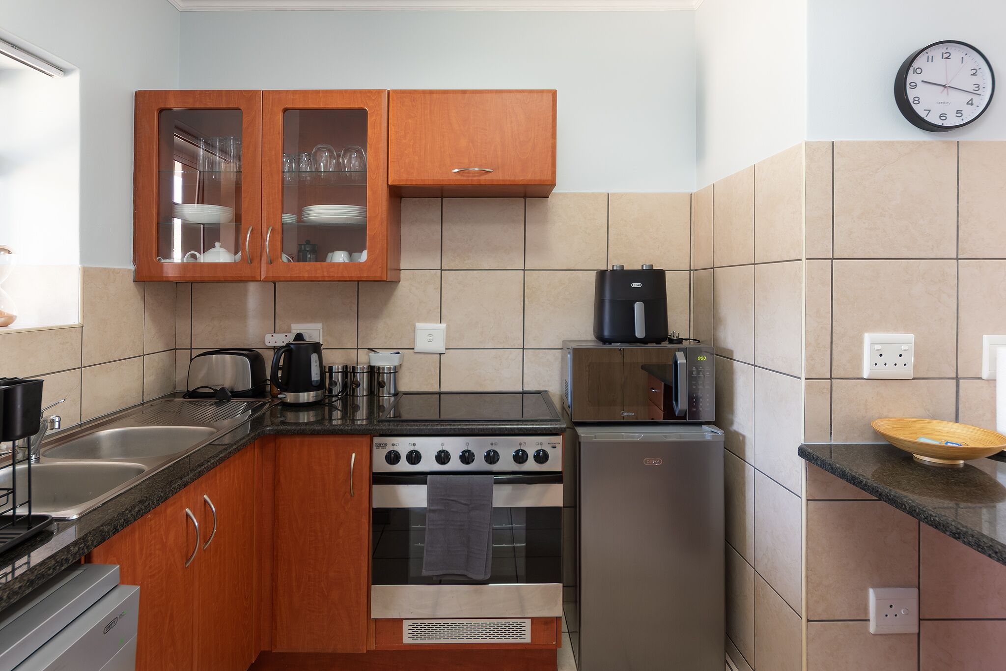 A kitchen with a stove, oven, refrigerator, and wooden cabinets.