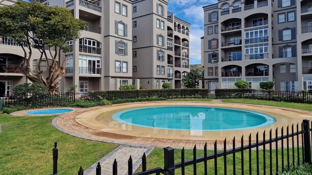 A residential building complex with a swimming pool and a well-maintained lawn. - me-Elohim  (Mossel Bay)