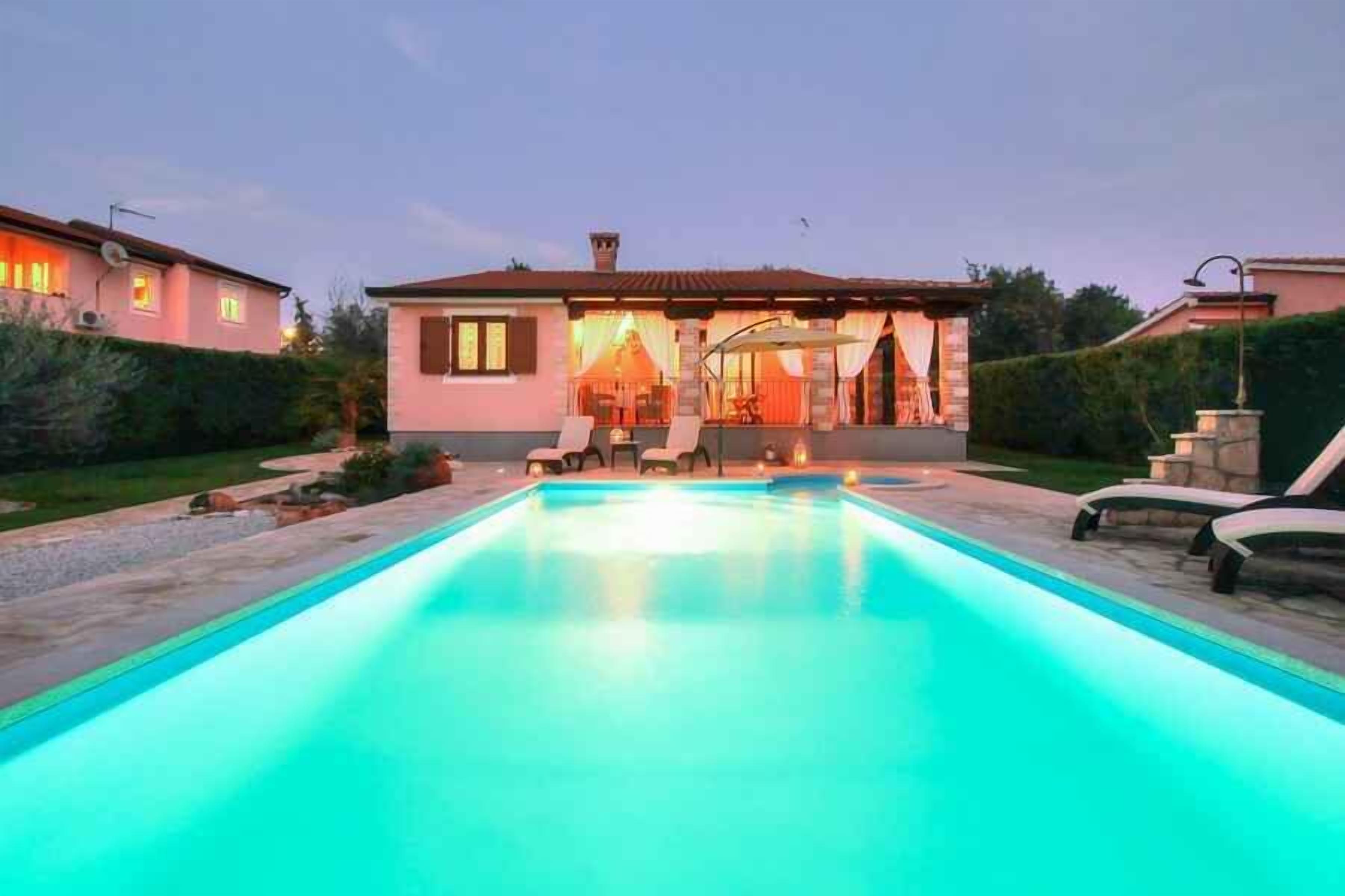 Une piscine avec des chaises longues et un espace patio couvert.