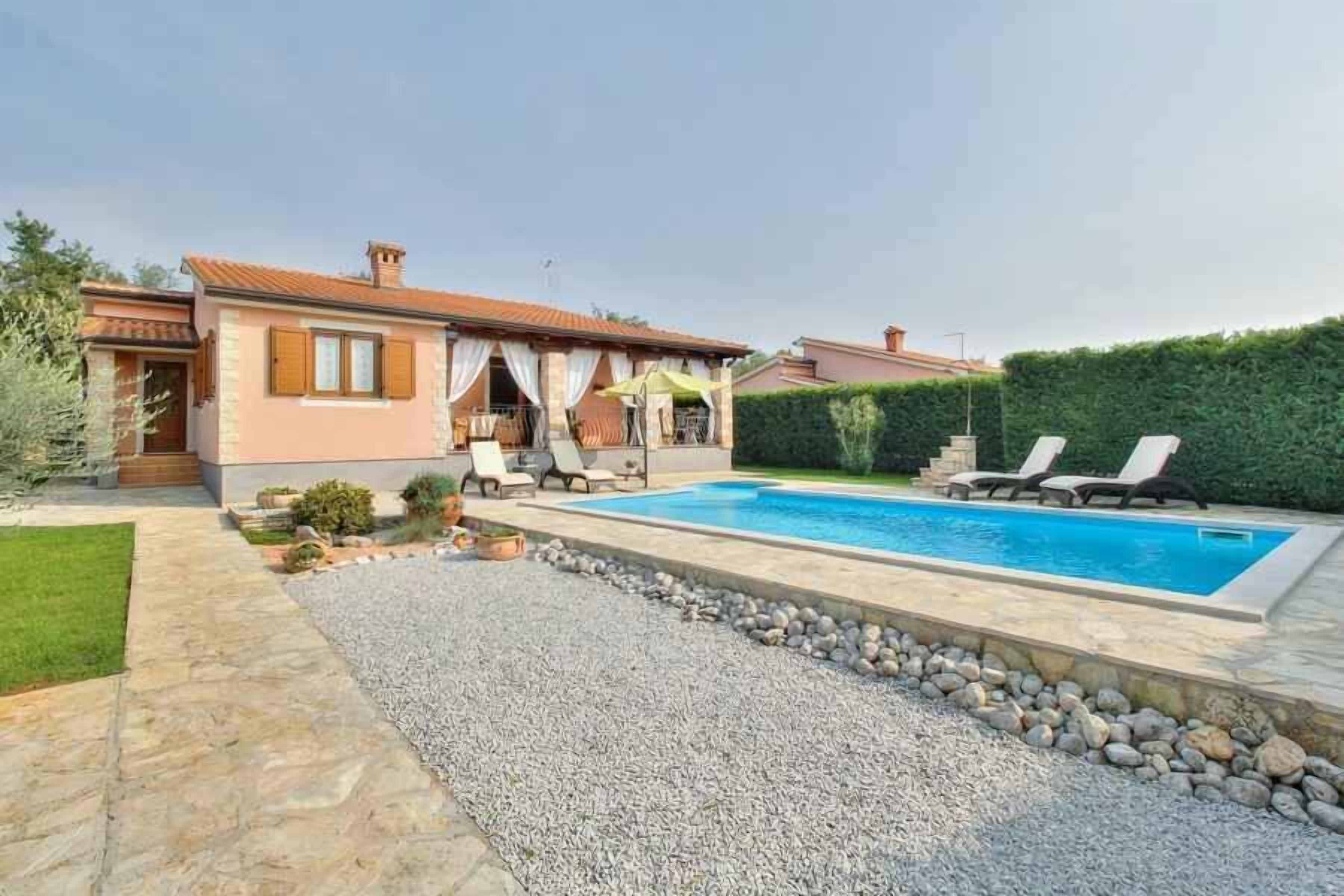 A house with a swimming pool, a covered patio, and a well-maintained garden.